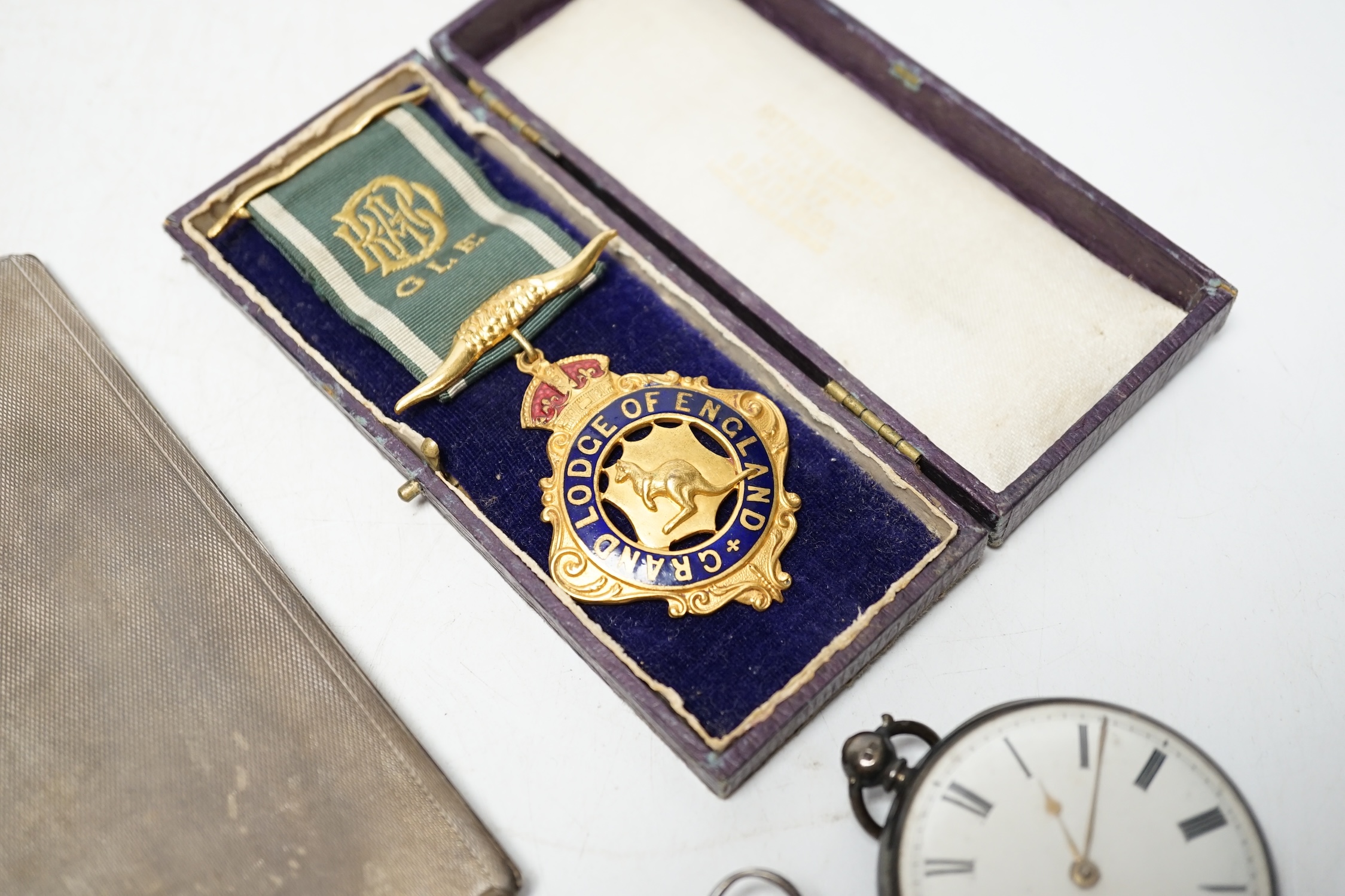 A George V engine turned silver cigarette case, 14.2cm, three pocket watches including two silver and a small group of coins and medals. Condition - poor to fair